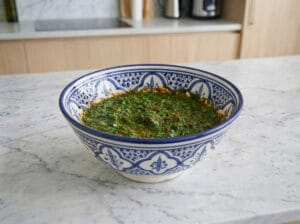 A Moroccan-patterned bowl with spices and finely chopped parsley