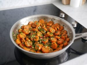 Chermoula-seasoned carrot rounds in a frying pan
