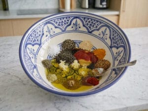 A bowl with spices, mustard, and oil
