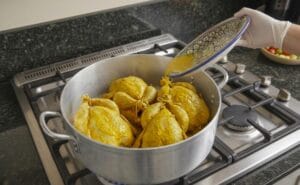 Adding Water: Pour 1 liter of hot water down the side of the pot (not over the chickens) to keep the spices on the meat