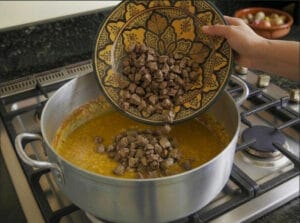 Adding the chopped chicken liver to the Dghmira onions