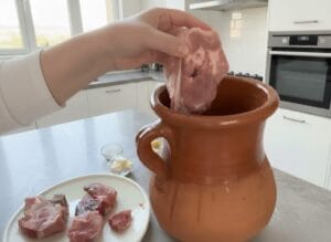 Placing meat into a clay Tangia pot, seasoned with preserved lemon and cumin