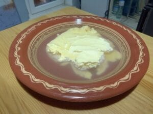 "A traditional Moroccan Gsaa (large wooden bowl) containing butter and cold water for washing it