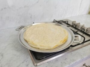 Multiple layers of rolled dough cooking on the baking griddle