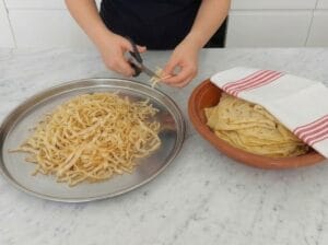Cutting the baked trid sheets into short strips while covering the remaining sheets with a kitchen towel