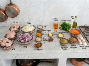 Ingredients for Moroccan Rfissa broth chicken, spices, and lentils arranged on the kitchen countertop