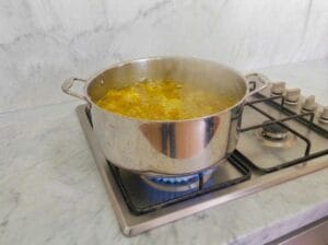Thickening the chicken broth in a large pot over the stove