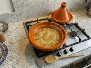 The rich juices and sauce remaining in the clay tagine after removing the cooked beef liver cubes