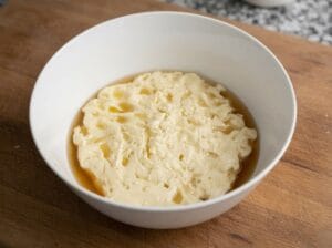 A large bowl containing butter mixed with a thyme infusion