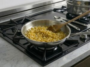 A frying pan with finely chopped onions, sautéed until soft, translucent, and golden