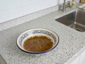 Raisins soaking in cold water in a bowl with traditional Moroccan patterns