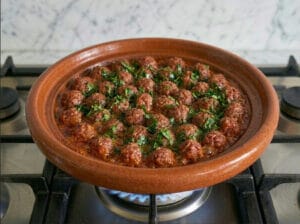 A traditional Moroccan tagine featuring meatballs rich tomato sauce