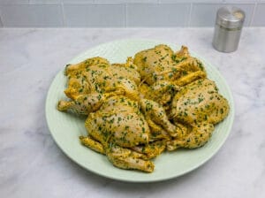 large plate full of seasoned chicken on the marble