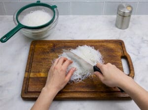 cutting the Chinese vermicelli with a knife on a wooden board