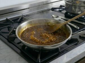 A frying pan containing the thickened, flavorful fish cooking juices and reduction