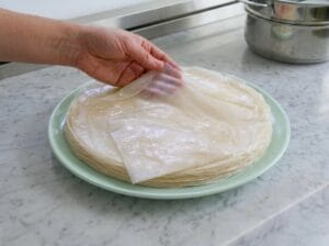 A light green plate containing stacked sheets of Moroccan warqa pastry