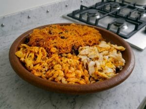 A Moroccan serving bowl filled with Chinese vermicelli stuffing, sautéed shrimp, sautéed squid, and fish fillets.