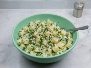 seasoning boiled potato cubes with parsley