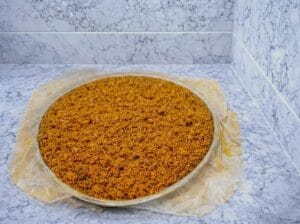 A baking tray lined with bastilla pastry sheets hanging over the edges, filled with Moroccan fish bastilla filling