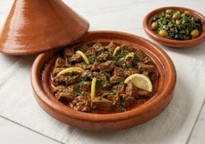 A traditional Moroccan beef liver tagine with onions, aromatic spices, and preserved lemon slices