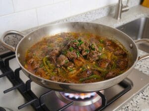A-stainless-steel-pan-with-onions-wilted-and-golden-green-peppers-spices-and-the-liver