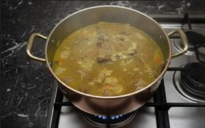 A pot of couscous broth simmering with tender pieces of meat