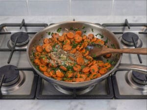 Carrot slices in a frying pan with Moroccan chermoula