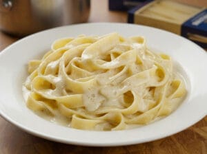 Classic fettuccine pasta dish topped with generous shaved Parmesan cheese