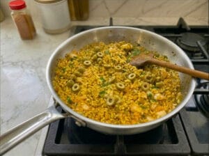 A pan featuring quick-cooking couscous mixed with green olive rings
