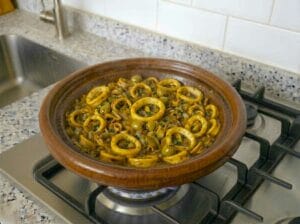 Traditional Moroccan tagine with calamari rings, onions, spices, and olives