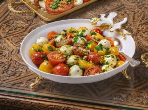 Halved cherry tomatoes with baby mozzarella mixed with pesto sauce.