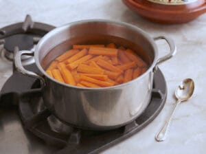 Carrot fingers in a pot of boiling water