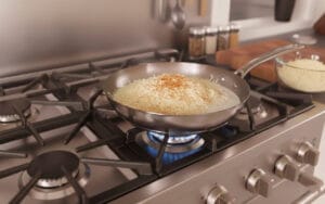A pan with heavy cream and grated Parmesan cheese