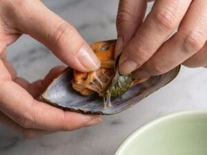 Hands cleaning mussels and removing the beard
