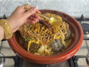 A female hand basting the fish with the sauce