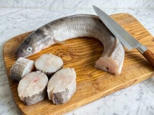 Cutting the middle to upper part of the conger eel fish into approximately 6 cm thick pieces